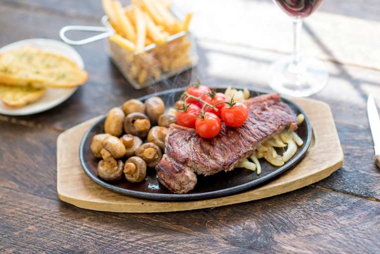 Devon Hotel Restaurant Dining Steak with Onion Vine Tomatoes Mushrooms and Chips