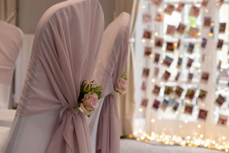 chairs with wedding covers and flowers