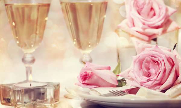 Wedding table place setting with roses and champagne