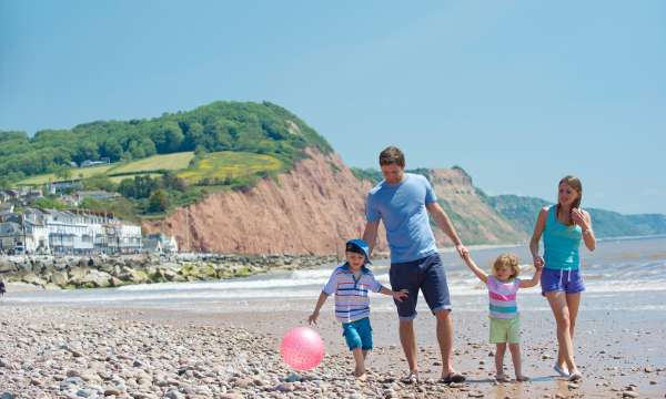 family of 4 walking on beach in Sidmouth