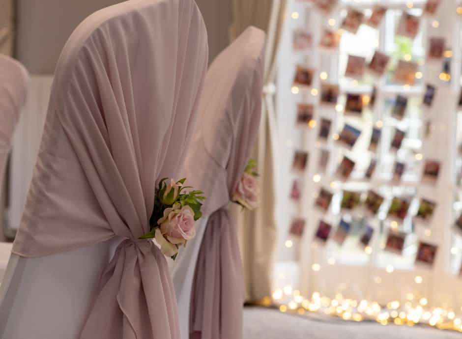 chairs with wedding covers and flowers