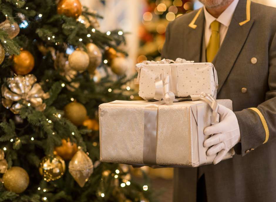 Man Holding Presents by Tree 