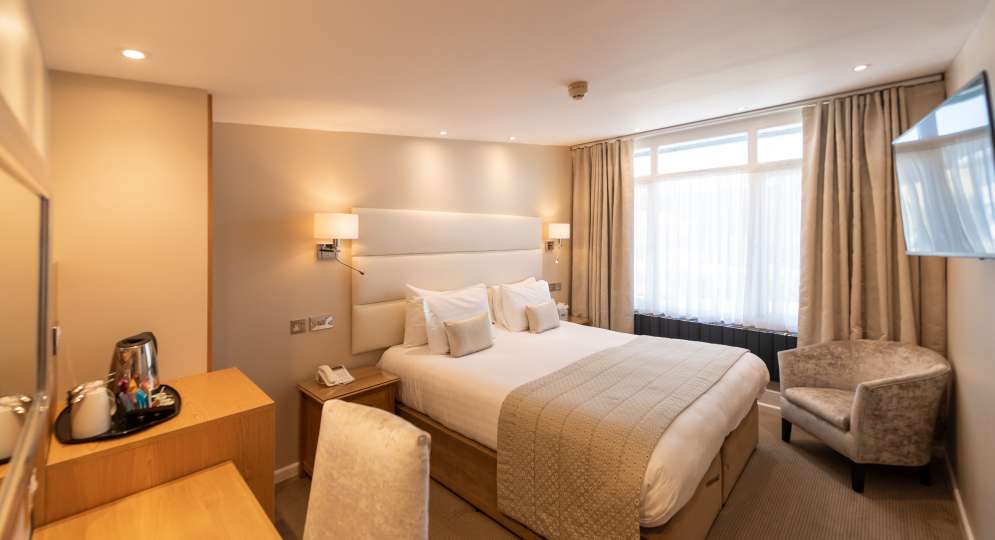 beige and white bedroom with wood furniture